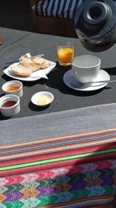 孔斯蒂图西翁Hotel Casa Puccllana的餐桌,盘子和一杯橙汁