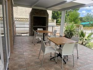 奥茨胡恩Stay@51 Botha的一个带桌椅和壁炉的庭院