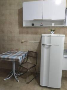 新弗里堡Casa Em Olaria, Nova Friburgo, Rua Manoel Lourenço Sobrinho 63 Fundos的厨房配有桌椅和冰箱。