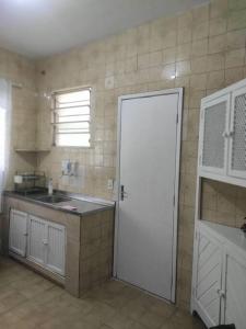 新弗里堡Casa Em Olaria, Nova Friburgo, Rua Manoel Lourenço Sobrinho 63 Fundos的厨房设有白色门和水槽