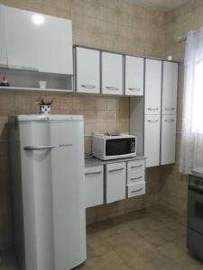 新弗里堡Casa Em Olaria, Nova Friburgo, Rua Manoel Lourenço Sobrinho 63 Fundos的厨房配有白色橱柜和微波炉