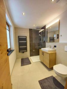 格罗萨尔Gästehaus Toferer的浴室配有卫生间、盥洗盆和淋浴。