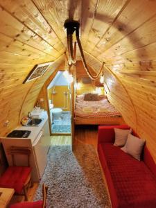 Crni VrhVila Jelena - BUNGALOV的小房间设有一张床和一张红色的沙发