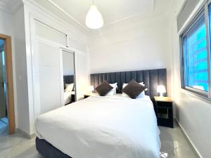 丹吉尔Tanger SABOR Central Aparts Fibre -ONLY FAMILY的卧室设有一张白色大床和一扇窗户。