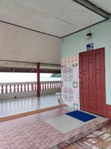 达叻府Chuttong resort的一间空房间,设有红色的门和一个阳台