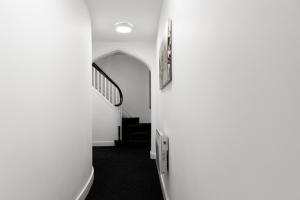 布赖尔利希尔Ledger Loft的一条带白色墙壁和楼梯的走廊