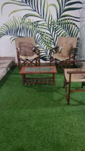 La PuntaDepartamento de playa con piscina en estreno的一间设有绿草和椅子及墙壁的房间