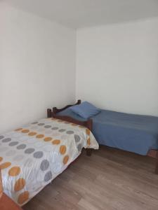 拉塞雷纳Rutero的一间卧室设有两张床,铺有木地板