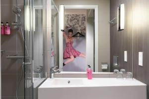 戴斯阿伯丁机场慕奇夕酒店的穿着浴室镜子的女性