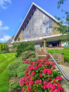 哈德斯菲尔德Cedar Court Hotel Huddersfield的前面有粉红色花的建筑