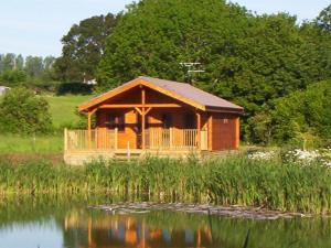 North PerrottWatermeadow Lakes & Lodges的湖滨小木屋,在水中反射