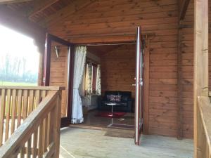 North PerrottWatermeadow Lakes & Lodges的通往小木屋的开放式门,小木屋配有椅子