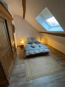 力宾Le grenier de Charlotte的一间卧室配有一张床和天窗