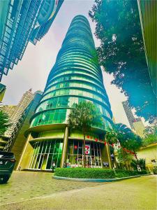 吉隆坡Vortex Suites KLCC by UNIQUE的前面有一棵树的高楼