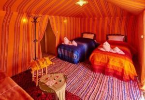 梅尔祖卡Desert Berber Fire-Camp的一间帐篷内带两张床的卧室