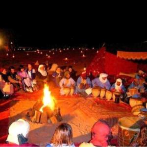 梅尔祖卡Desert Berber Fire-Camp的一群人围坐在火炉旁