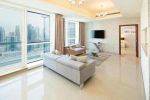 迪拜Marina Two Bedroom With Balcony - KV Hotels的客厅配有白色沙发和大窗户
