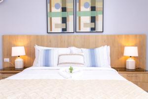 HigueyHabana Hotel Y Restaurante的一间卧室配有一张带两盏灯的大型白色床。