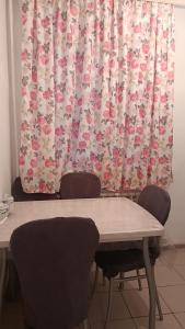 巴甫洛达尔3-х комнатная квартира в Павлодаре的窗帘前的桌椅