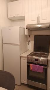 巴甫洛达尔3-х комнатная квартира в Павлодаре的厨房配有炉灶和冰箱。