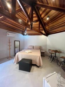 沙帕达-杜斯吉马朗伊斯Pousada Vila Margarida的一间卧室配有一张大床和一张桌子