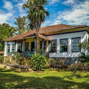 巴纳纳尔Fazenda Dos Coqueiros-Bananal-SP的前面有棕榈树的房子