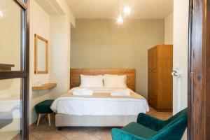 埃拉蒂特里卡隆卡塔费吉欧酒店的一间卧室配有一张床和一把绿色椅子
