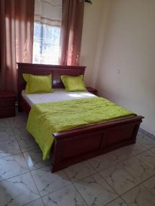 EmanaRESIDENCE E.P的一间卧室配有一张带绿色棉被的床和窗户。