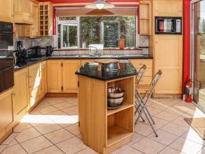 Ballymoney Cross RoadsSeafield的厨房配有木制橱柜和黑色台面
