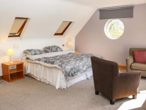 Ballymoney Cross RoadsSeafield的一间卧室配有一张床和一把椅子