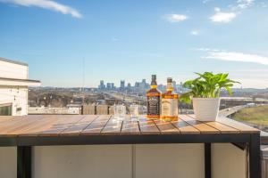 纳什维尔Jack Daniels House with Rooftop Golf, City views! 8min to Whiskey Row! Sleeps 10!的阳台上桌子上放着三瓶威士忌