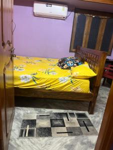 蒂鲁帕蒂SM Homestays 2的一间卧室配有一张带黄床单的床和风扇