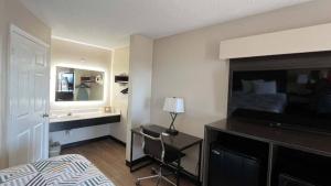 乔治敦Motel 6 Georgetown, SC Marina的酒店客房带一张床铺、一张书桌和一间卧室