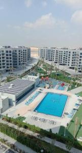 迪拜Modern 1BR in Dubai South Mag5 with all utilities的城市游泳池的顶部景观