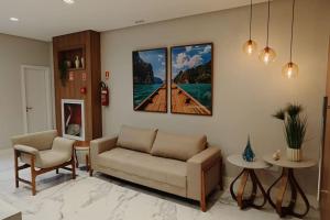 瓜拉派瑞Lindo apartamento em Guarapari - Novinho - Vista Maravilhosa的客厅配有沙发和墙上的两幅画作