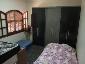 卡波布里奥Casa de praia em Cabo Frio até 12 hospedes的一间卧室配有床、橱柜和窗户
