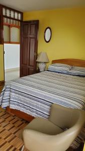 查查波亚斯Guiltor host的一间卧室配有一张大床和一把椅子