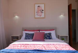 DhalamanáraTo Spitaki Dalamanara的一间卧室配有一张带粉红色和蓝色棉被的床