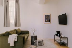 伦敦Sonder Chelsea Green的客厅配有绿色沙发和电视