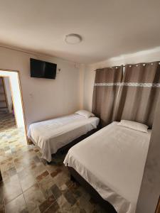 伊基克El Pescador的客房设有两张床和一台平面电视。