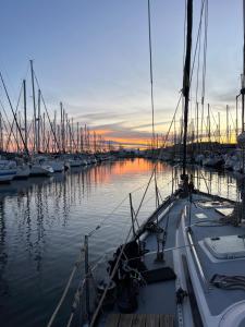格吕桑Voilier traditionnel, tout confort et au calme的日落时分停靠在码头的一组船