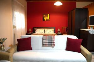 埃泽萨Cottage Lina的一间卧室配有一张红色墙壁的床和一张沙发