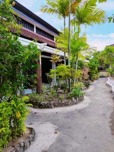 库塔Berlian Inn Kuta Beach的棕榈树庭院和建筑