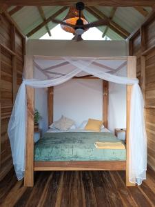 帕洛米诺La Mona Eco Cabins的一间卧室配有一张带天蓬的床