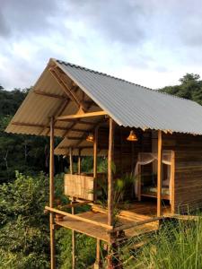 帕洛米诺La Mona Eco Cabins的田野上带锡屋顶的木屋