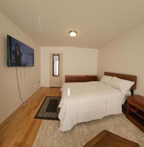 纽瓦克Traveler's Lodge In Newark City的卧室配有一张床,墙上配有电视