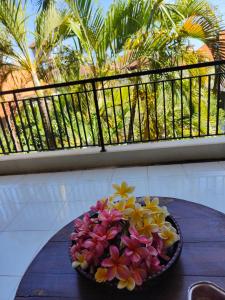 库塔Berlian Inn Kuta Beach的阳台上的桌子上放着一碗鲜花