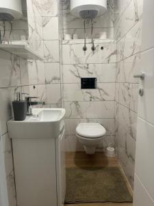 亚霍里纳Apartmani Andjela的白色的浴室设有卫生间和水槽。