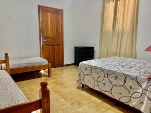 弗洛里亚诺波利斯Floripa Camping e Hostel的一间卧室设有两张床和木门