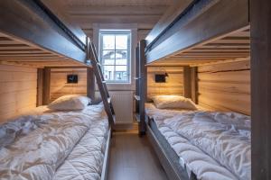 萨伦Exklusiv ski in-ski out stuga, i Hundfjället Sälen的木墙客房的两张双层床